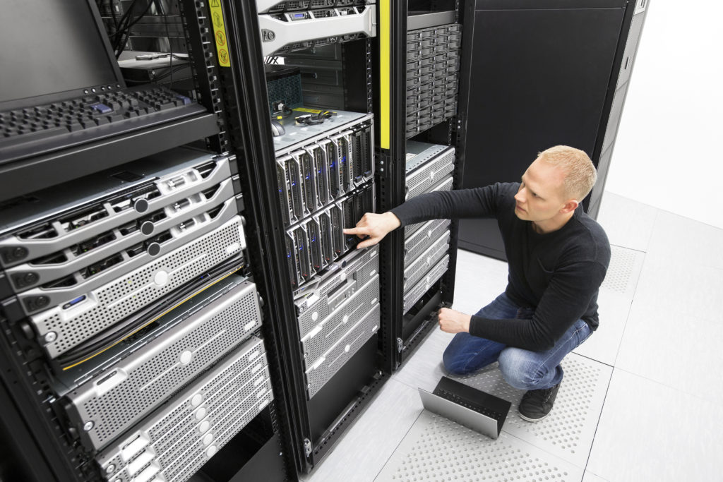 It engineer or technician monitors blade servers in data rack. Working in datacenter.