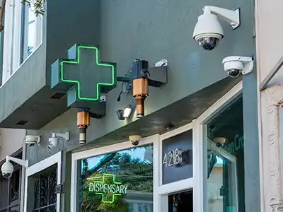The front door to a medical marijuana dispenssary with security cameras watching over the security-locked door.