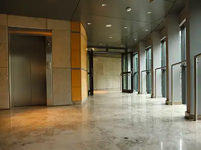 The interior hallway of a modern apartment complex with security doors that feature a key fob and pin entry system.